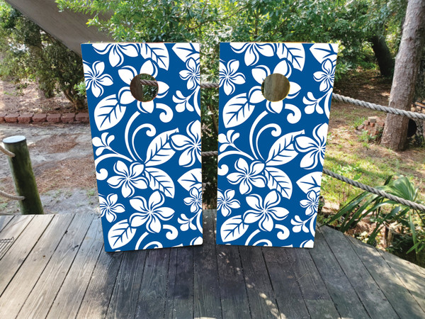 cornhole boards featuring white tiki flowers on a blue background.