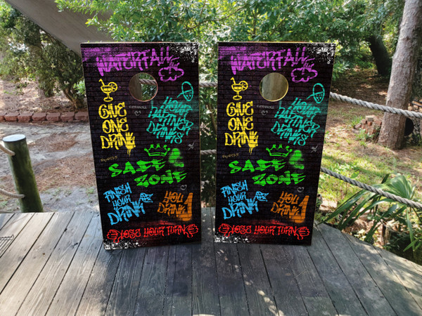 Graffiti-style drinking game cornhole boards with vibrant street art graphics and drink markers, built to professional regulation standards.