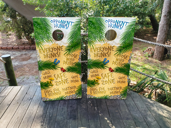 Beach-themed drinking game cornhole boards with vibrant coastal graphics, featuring tropical elements and drink markers, built to professional regulation standards.