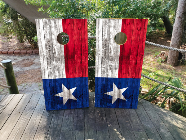 Cornhole boards featuring a wooden waving TX flag