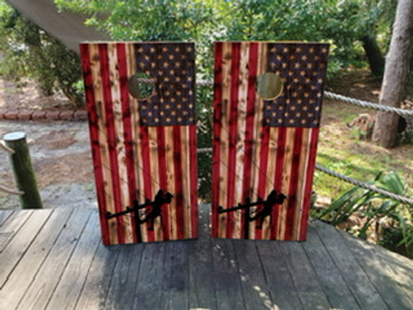 Cornhole boards featuring a wood grain USA flag and revealing a silhouette of a lineman climbing a pole