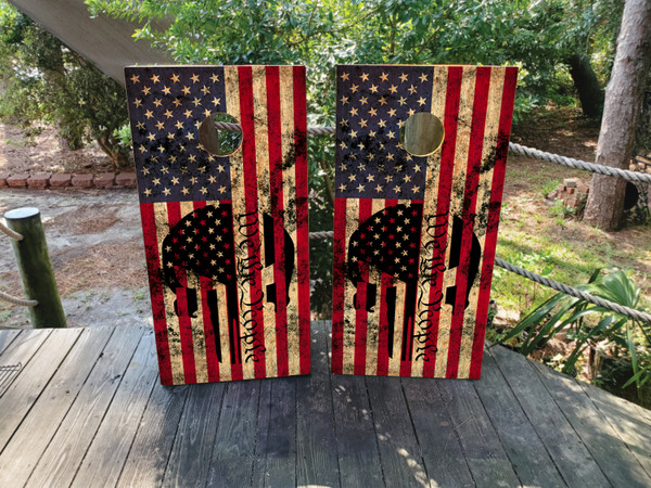 Cornhole boards featuring a USA American flag with We The People and a skull