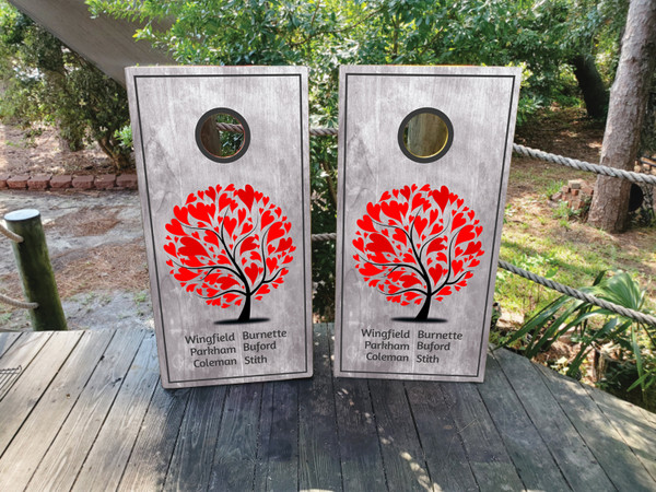 A cornhole board featuring a family tree made of hearts