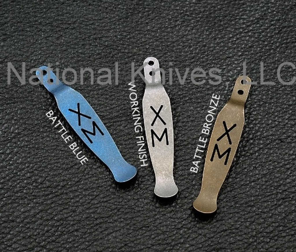 Rick Hinderer Knives XM Pocket Clip - obverse shown along with 2 other colors.  Battle Blue titanium construction.  Model K0020001TD-BTLBL.
For reference only.