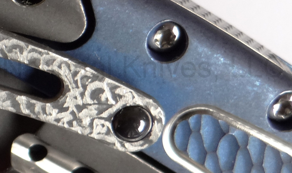 Todd Begg Knives Bodega 2.0 folding knife with flipper tab - shown close up of pocket clip.  2-tone N690 stainless steel plain edge blade.  Blue titanium handle.
For reference only.