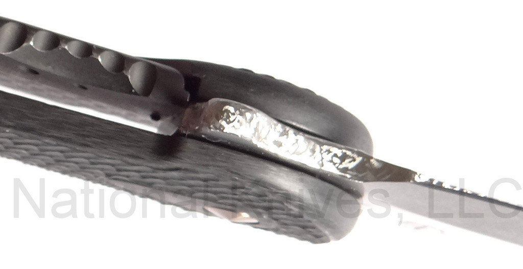 Todd Begg Knives Bodega Field Grade folding knife with flipper tab - shown close up of lock.  2-tone N690 stainless steel plain edge blade.  Carbon fiber handle.
For reference only.