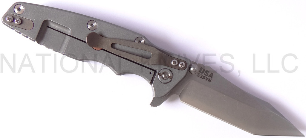 Rick Hinderer Knives Eklipse Tanto folding knife with thumb stud and flipper tab - shown open lock side.  Stonewash S35VN stainless steel plain edge blade.  Black G-10 handle with Working Finish lock side.  Model K40040TD00.
For reference only.