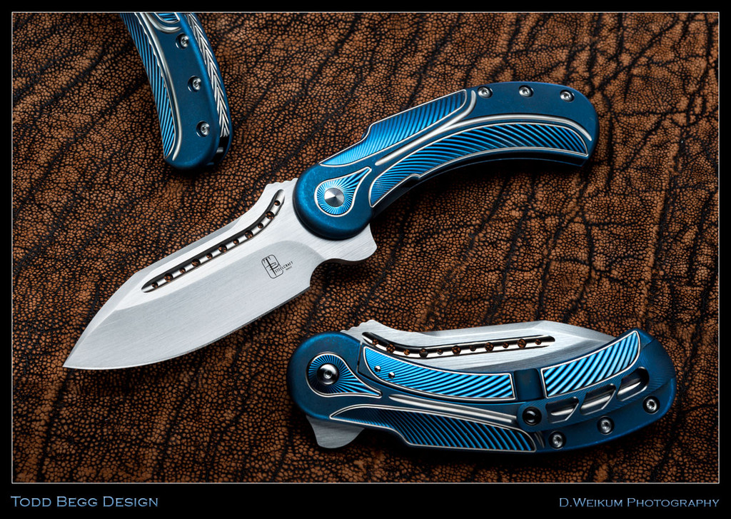 Todd Begg Knives Steelcraft Series Field Marshall folding knife - shown open presentation side, closed pocket clip side, and close up of back spacer.  Hand Satin S35VN stainless steel plain edge blade.  Blue and Silver titanium handle.  Model FM233.
For reference only.