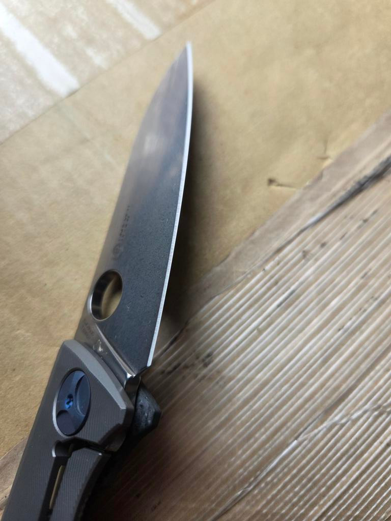 Used Spyderco Drunken folding knife with thumb hole - close up of lock side blade shown.  Satin S90V stainless steel plain edge blade.  Black carbon fiber handle with titanium lock side.  Model C235CFTIP.