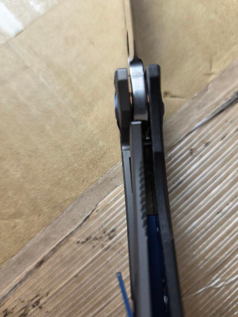 Used Spyderco Drunken folding knife with thumb hole - close up of lock shown.  Satin S90V stainless steel plain edge blade.  Black carbon fiber handle with titanium lock side.  Model C235CFTIP.