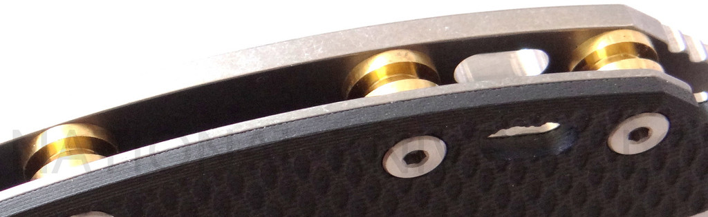 Rick Hinderer Knives Horse Head Logo Fatty XM-18 3.5" Harpoon Tanto folding knife with thumb stud and flipper tab - close up of standoffs.  Stonewash S35VN stainless steel plain edge blade.  Black G-10 handle with stonewash lock side.  Model K2506SGS00.
For reference only.