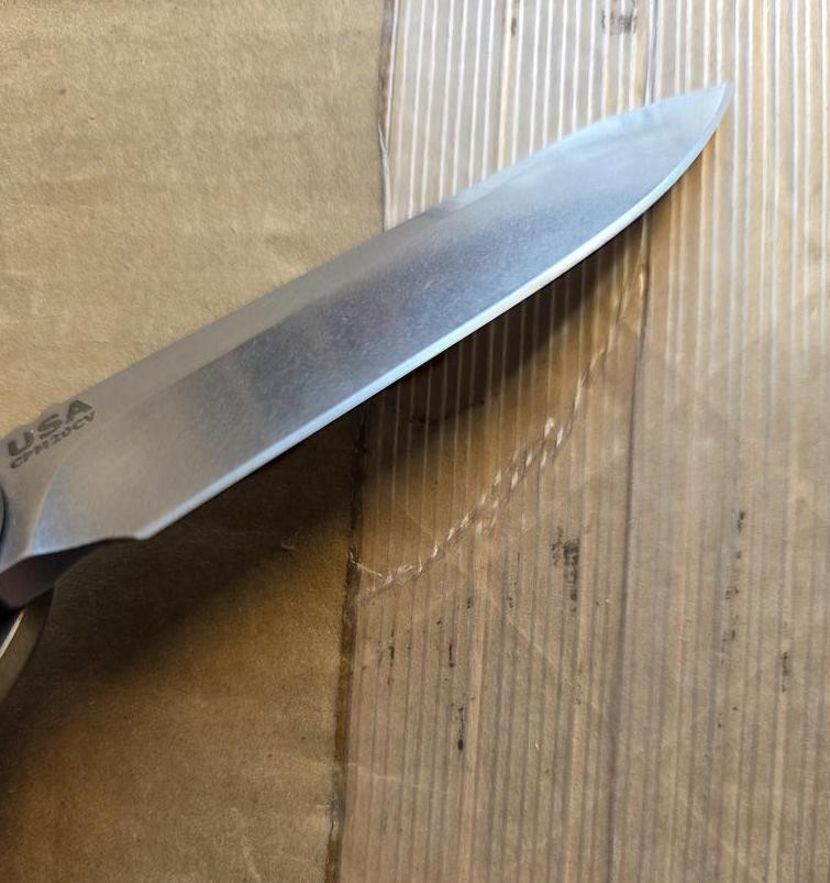 USED Rick Hinderer Knives XM-18 Automatic Spearpoint knife with push button - close up of pocket clip side blade shown.  Stonewash 20CV stainless steel plain edge blade.  Anodized bronze titanium handle. 