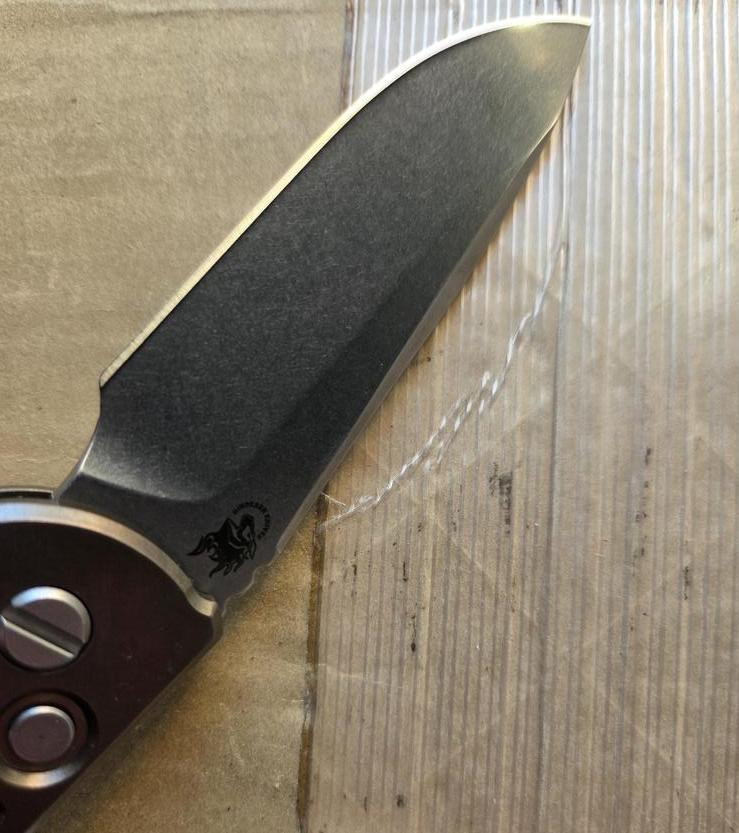 USED Rick Hinderer Knives XM-18 Automatic Spearpoint knife with push button - close up of presentation side blade shown.  Stonewash 20CV stainless steel plain edge blade.  Anodized bronze titanium handle. 