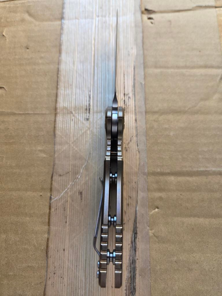 USED Rick Hinderer Knives XM-18 Automatic Spearpoint knife with push button - close up of bottom view of handle.  Stonewash 20CV stainless steel plain edge blade.  Anodized bronze titanium handle. 