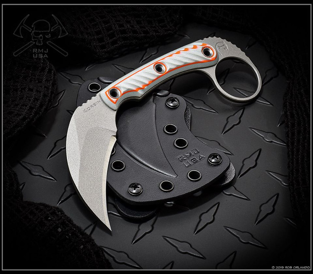 RMJ Tactical Explore More Korbin Karambit fixed blade knife - shown out of sheath obverse.  Gray Cerakote Nitro-V stainless steel plain edge blade.  Gray and orange G-10 handle.  
For reference only.