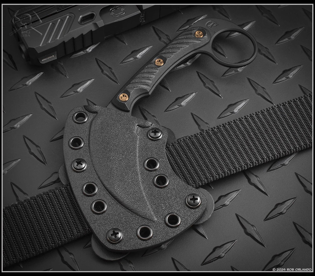 RMJ Tactical Korbin Karambit fixed blade knife - shown in sheath obverse.  Graphite Black Cerakote Nitro-V stainless steel plain edge blade.  Black G-10 handle.  Model K-KO-BL-BL.