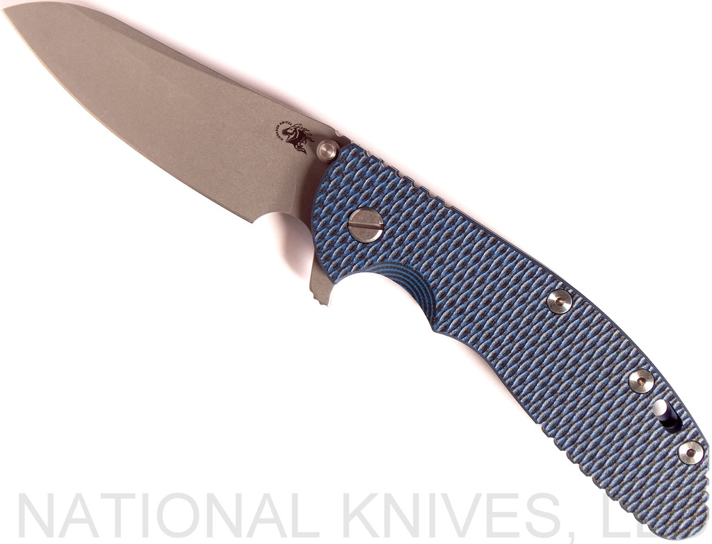 Rick Hinderer Knives XM-24 Sheepsfoot folding knife with thumb stud and flipper tab - shown open presentation side.  Working Finish 20CV stainless steel plain edge blade.  Blue - black G-10 handle with Battle Blue lock side.  Model K3073SGW00.
