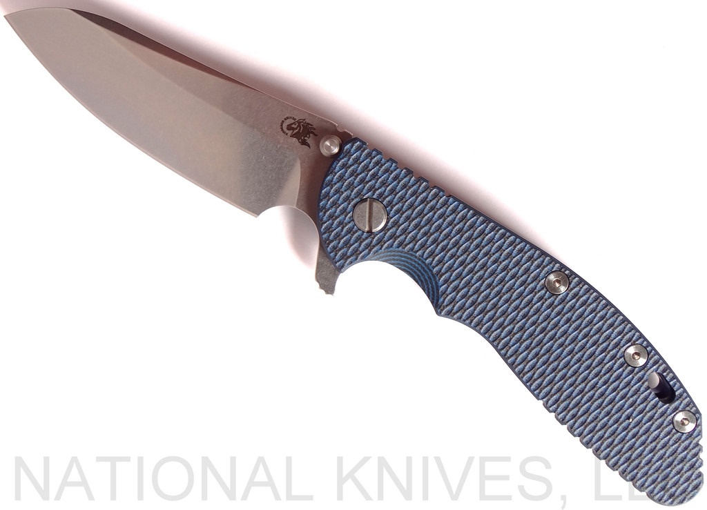 Rick Hinderer Knives XM-24 Sheepsfoot folding knife with thumb stud and flipper tab - shown open presentation side.  Stonewash 20CV stainless steel plain edge blade.  Blue - black G-10 handle with stonewash blue lock side.  Model K3073SGS00.
