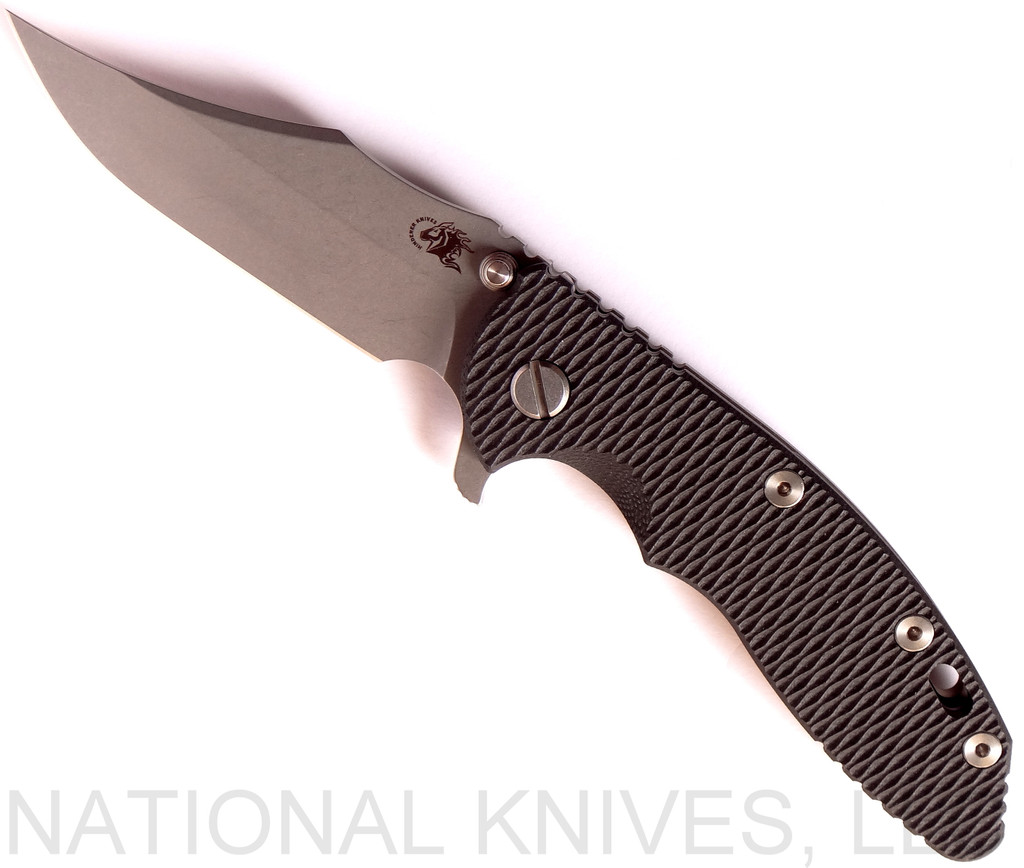 Rick Hinderer Knives XM-18 3.5" Bowie folding knife with thumb stud and flipper tab - shown open presentation side.  Working Finish 20CV stainless steel plain edge blade.  Black G-10 handle with Battle Bronze titanium lock side.  Model K2032SGW00.