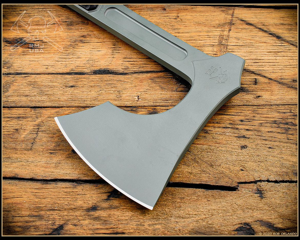 RMJ Tactical 3V Syndicate Raven tomahawk - shown close up of head out of sheath obverse.  Jungle Green Cerakote CPM-3V steel plain edge head.  Black G-10 handle.
For reference only.