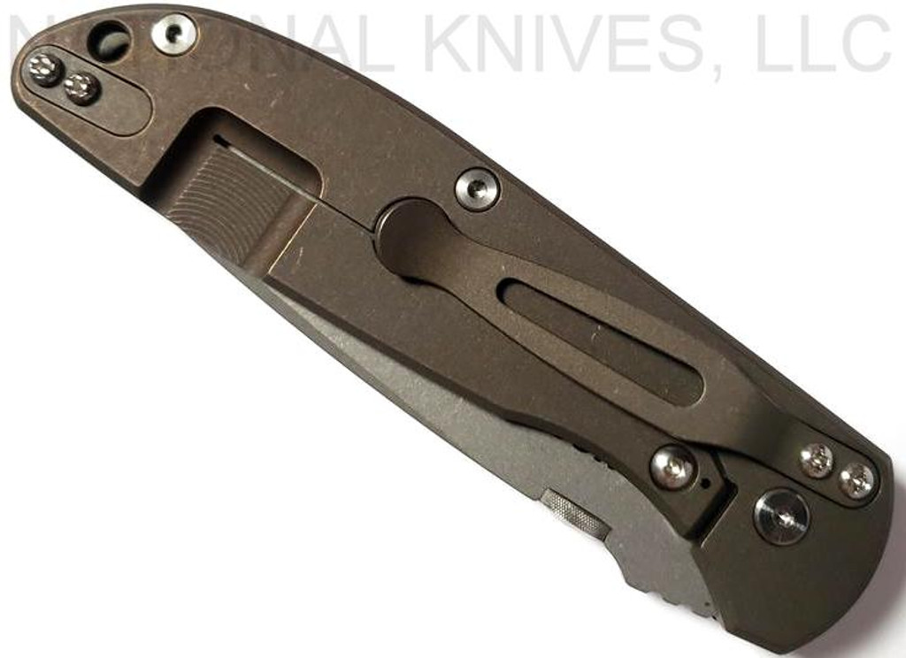 Rick Hinderer Knives Firetac Recurve folding knife with thumb disk - shown closed lock side.  Working Finish 20CV stainless steel plain edge blade.  Black G-10 handle with Battle Bronze lock side.  Model K205FSGW00.