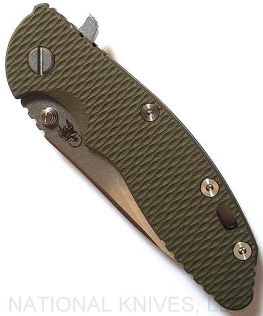 Rick Hinderer Knives XM-18 3.5" Slicer folding knife with thumb stud and flipper tab - shown closed presentation side.  Stonewash 20CV stainless steel plain edge blade.  OD green G-10 handle with stonewash bronze lock side.  Model K310102S000.