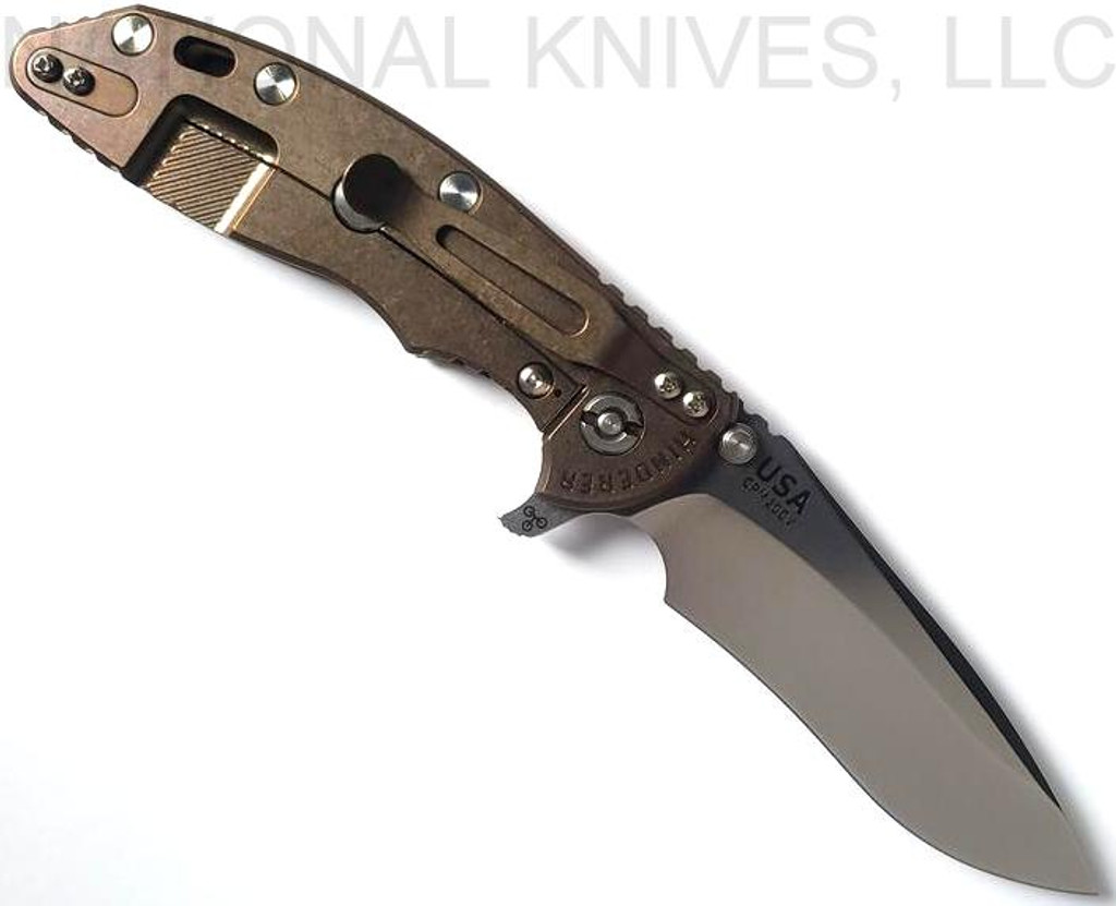 Rick Hinderer Knives XM-18 3.5" Recurve folding knife with thumb stud and flipper tab - shown open lock side.  Stonewash 20CV stainless steel plain edge blade.  OD green G-10 handle with stonewash bronze lock side.  Model KXM35REC.