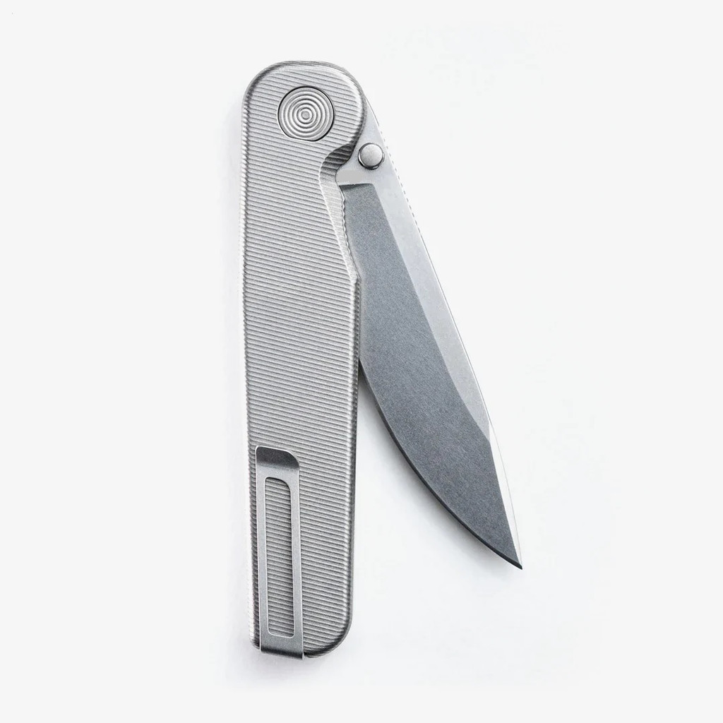 Tactile Knife Co Rockwall folding knife with a thumb stud - shown partially open pocket clip side.  Stonewashed MagnaCut stainless steel plain edge blade.  Titanium handle.  Model 20-RT-MC01-TT01.