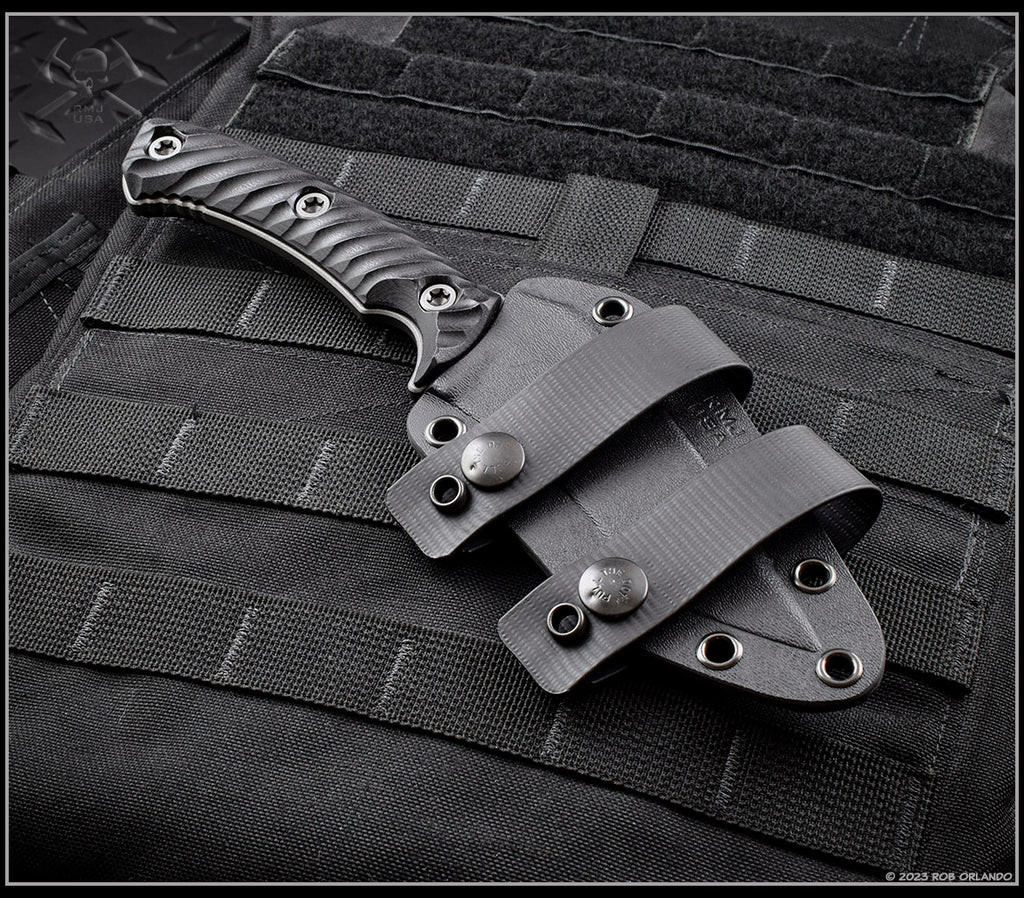 RMJ Tactical Peregrine fixed blade knife - shown in sheath obverse.  Tungsten Cerakote Nitro-V stainless steel plain edge blade.  Black G-10.