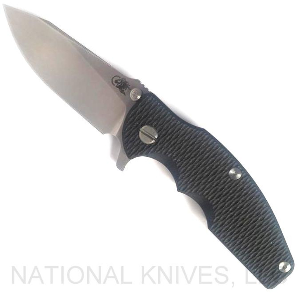 Rick Hinderer Knives Jurassic Slicer folding knife with thumb stud and flipper tab - shown open presentation side.  Stonewash MagnaCut stainless steel plain edge blade.  Black G-10 handle scale with stonewash titanium lock side.  Model KJURSLMC.