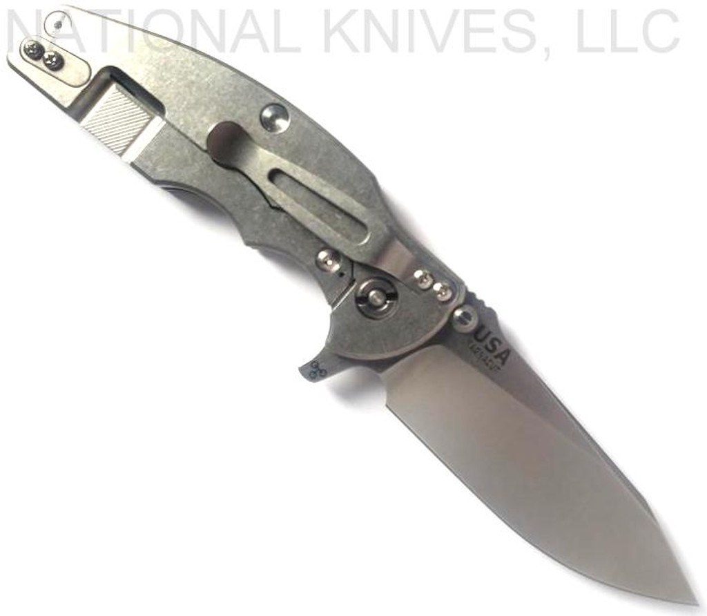 Rick Hinderer Knives Jurassic Slicer folding knife with thumb stud and flipper tab - shown open lock side.  Stonewash MagnaCut stainless steel plain edge blade.  Black G-10 handle scale with stonewash titanium lock side.  Model KJURSLMC.