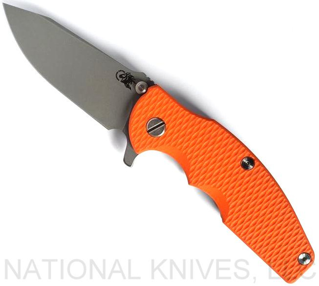 Rick Hinderer Knives Jurassic Slicer folding knife with thumb stud and flipper tab - shown open presentation side.  Working Finish MagnaCut stainless steel plain edge blade.  Orange G-10 handle scale with Battle Blue lock side.  Model KJURSLMC.