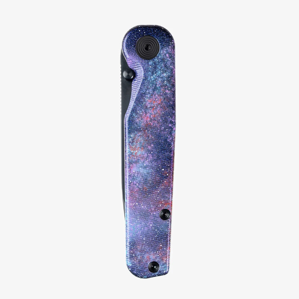 Tactile Knife Co Seasonal Release Deep Space Rockwall folding knife with thumb stud - shown closed presentation side.  Black MagnaCut stainless steel plain edge blade.  Deep Space themed titanium handle.
For reference only.