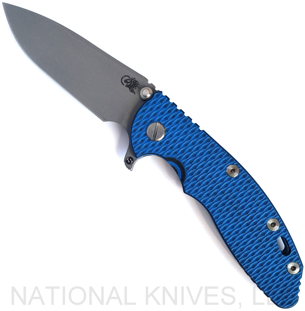 Rick Hinderer Knives Skinny XM-18 3.5" Slicer folding knife with thumb stud and flipper tab - shown open presentation side.  Working Finish MagnaCut stainless steel plain edge blade.  Blue - black G-10 handle with Battle Blue lock side.  Model KXM35SKSL.