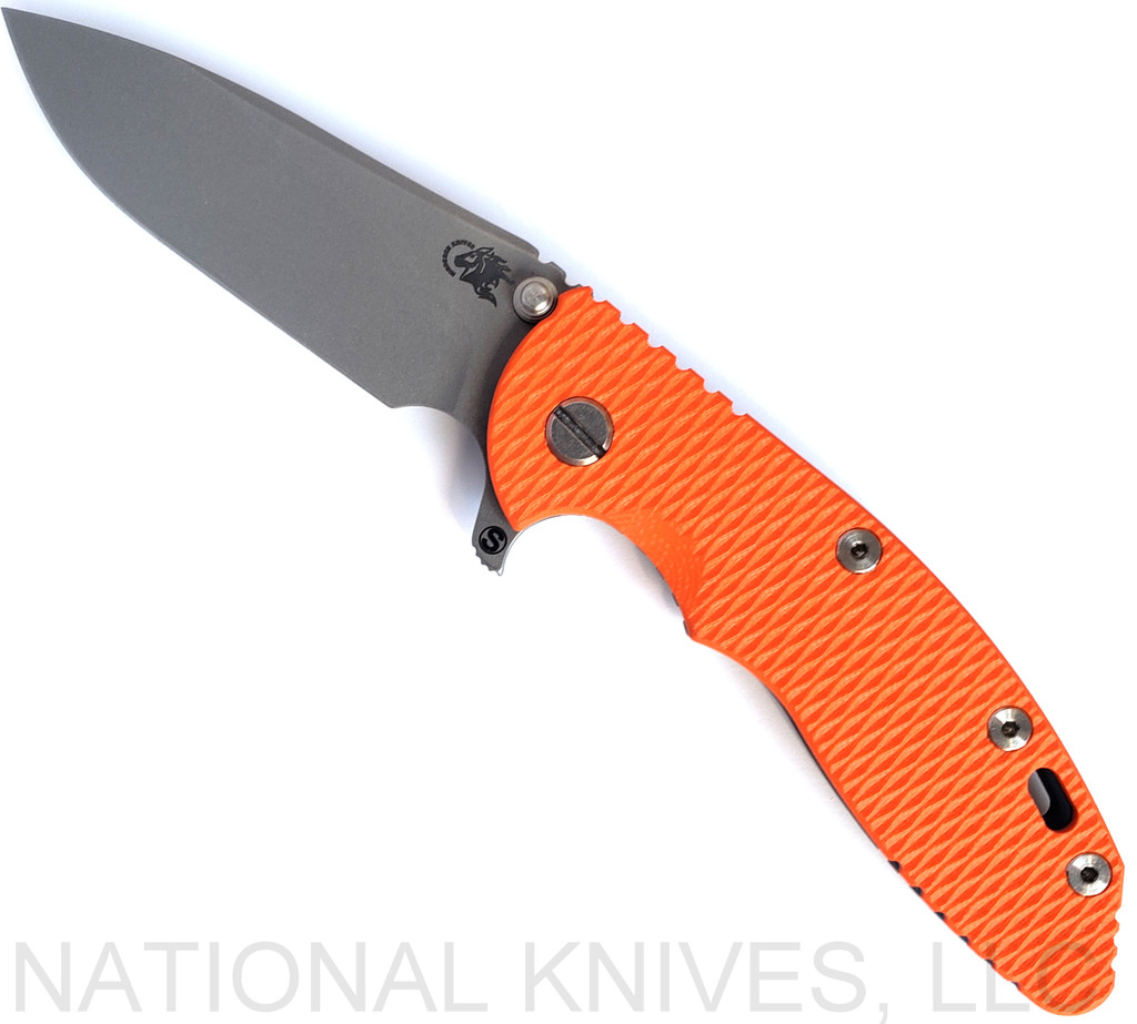 Rick Hinderer Knives Skinny XM-18 3.5" Slicer folding knife with thumb stud and flipper tab - shown open presentation side.  Working Finish MagnaCut stainless steel plain edge blade.  Orange G-10 handle with Battle Blue lock side.  Model KXM35SKSL.