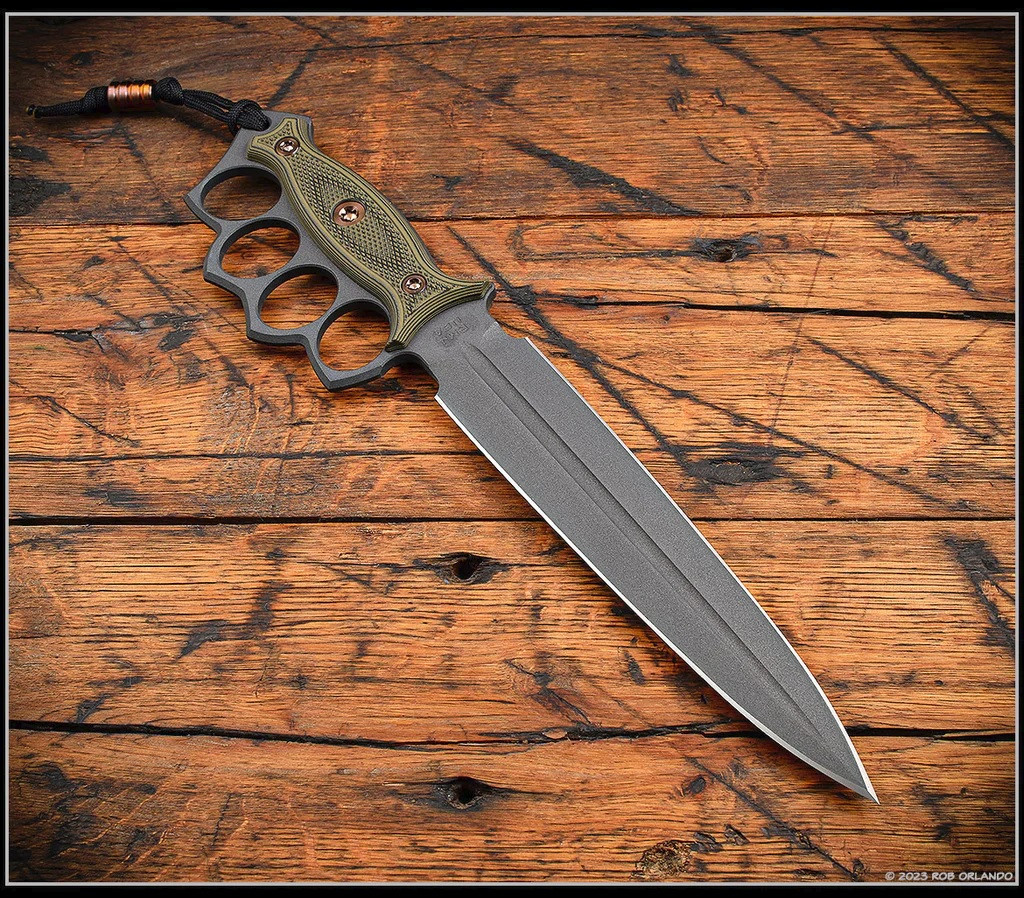 RMJ Tactical Lady Death fixed blade knife - shown out of sheath obverse.  Cobalt Cerakote MagnaCut stainless steel plain edge blade.  Dirty Olive G-10 handle.  Model K-LD-MC-CO-DO-BG.