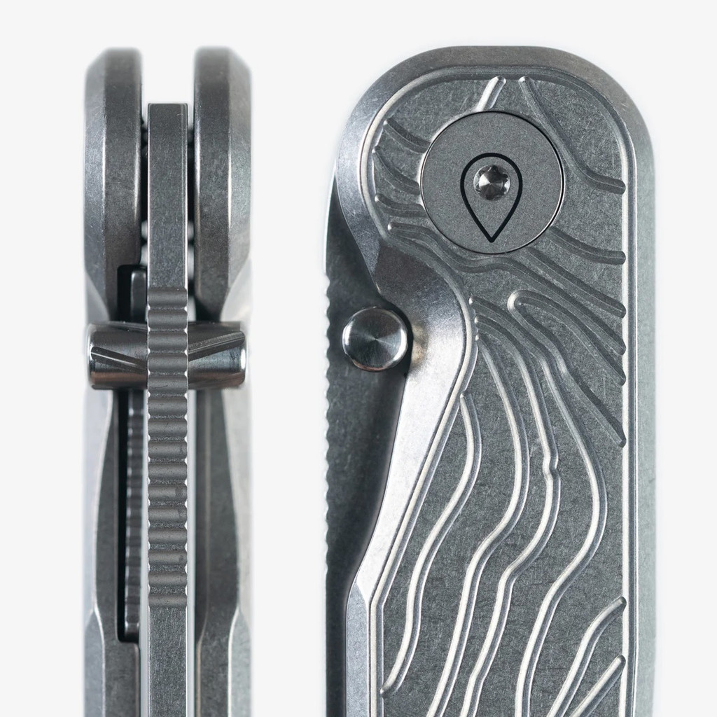 Tactile Knife Co Topographical Rockwall folding knife with thumb stud - close up of thumb stud and pivot and thumb stud - two views.  Stonewashed MagnaCut stainless steel plain edge Tanto blade.  Topographical titanium handle.  Model 20-RT-MCTN-TOPO.