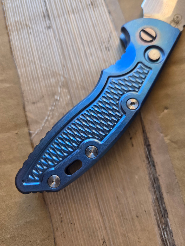 USED Rick Hinderer Knives XM-18 Automatic Spearpoint knife with push button - close up of presentation side handle shown.  Stonewash 20CV stainless steel plain edge blade.  Anodized blue titanium handle. 