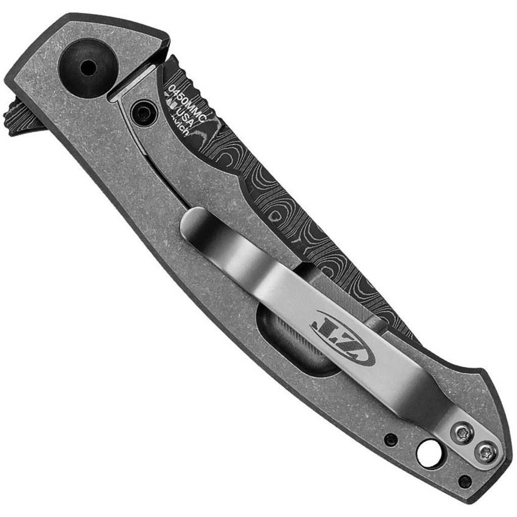 Zero Tolerance 0450MMC folding knife with flipper tab - closed - lock side.  3.25" Vegas Forge Damascus steel plain edge blade.  Multi color carbon fiber handle.  Model 0450MMC.