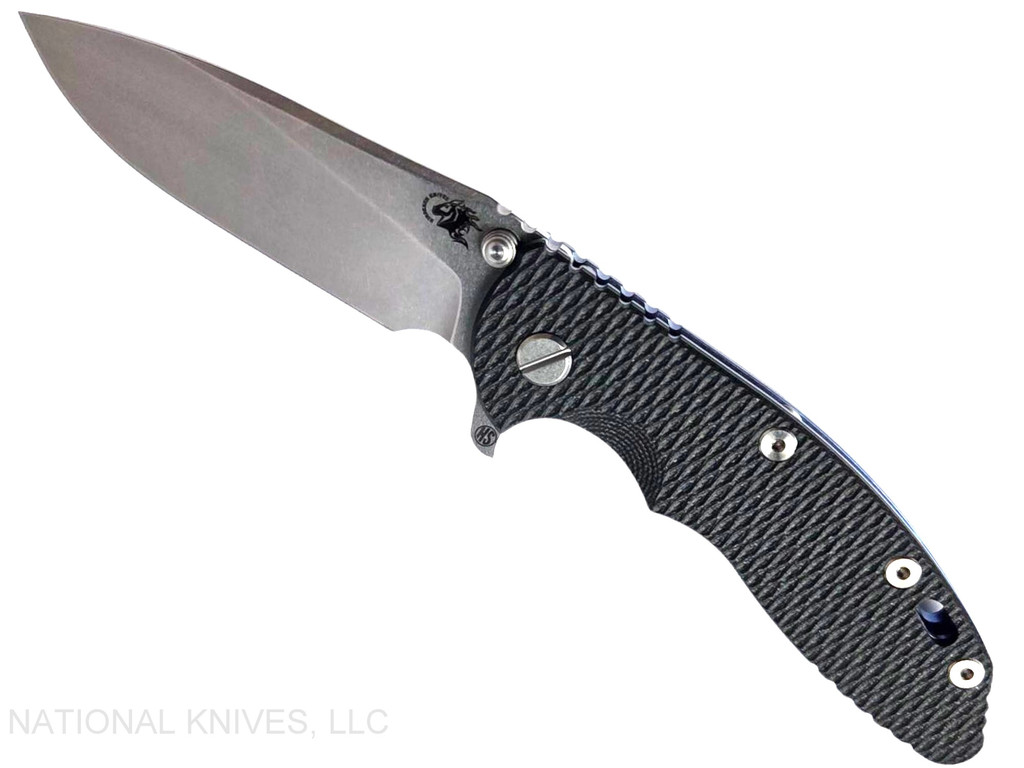 Rick Hinderer Knives XM-18 Skinny Slicer with thumb stud and flipper tab - shown open presentation side.  Stonewash Magnacut stainless steel, hollow ground, plain edge blade.  Black G-10 handle with stonewash blue lock side. 
