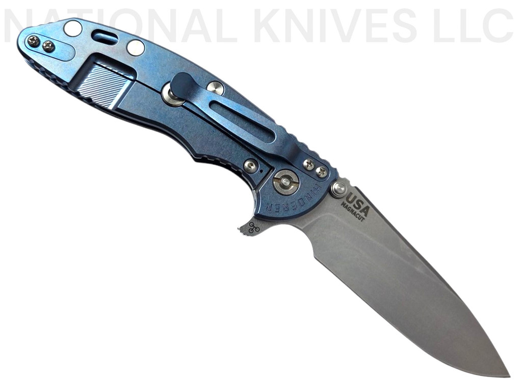 Rick Hinderer Knives XM-18 Skinny Slicer with thumb stud and flipper tab - shown open lock side.  Stonewash Magnacut stainless steel, hollow ground, plain edge blade.  Black G-10 handle with stonewash blue lock side. 