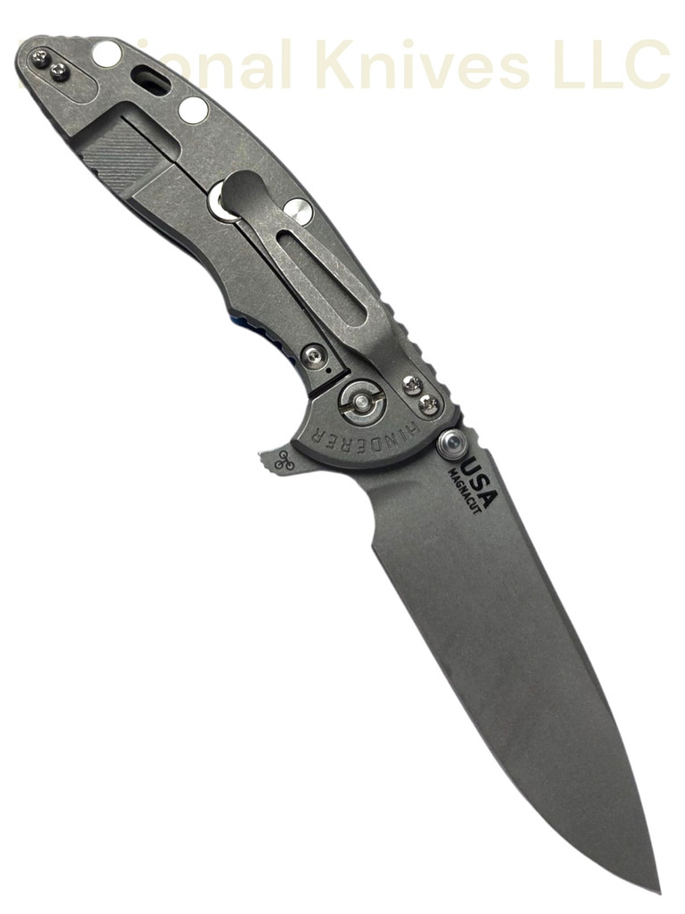 Rick Hinderer Knives XM-18 Skinny Slicer with thumb stud and flipper tab - shown open lock side.  Working Finish Magnacut stainless steel, hollow ground, plain edge blade.  Blue - Black G-10 handle with Working Finish lock side. 