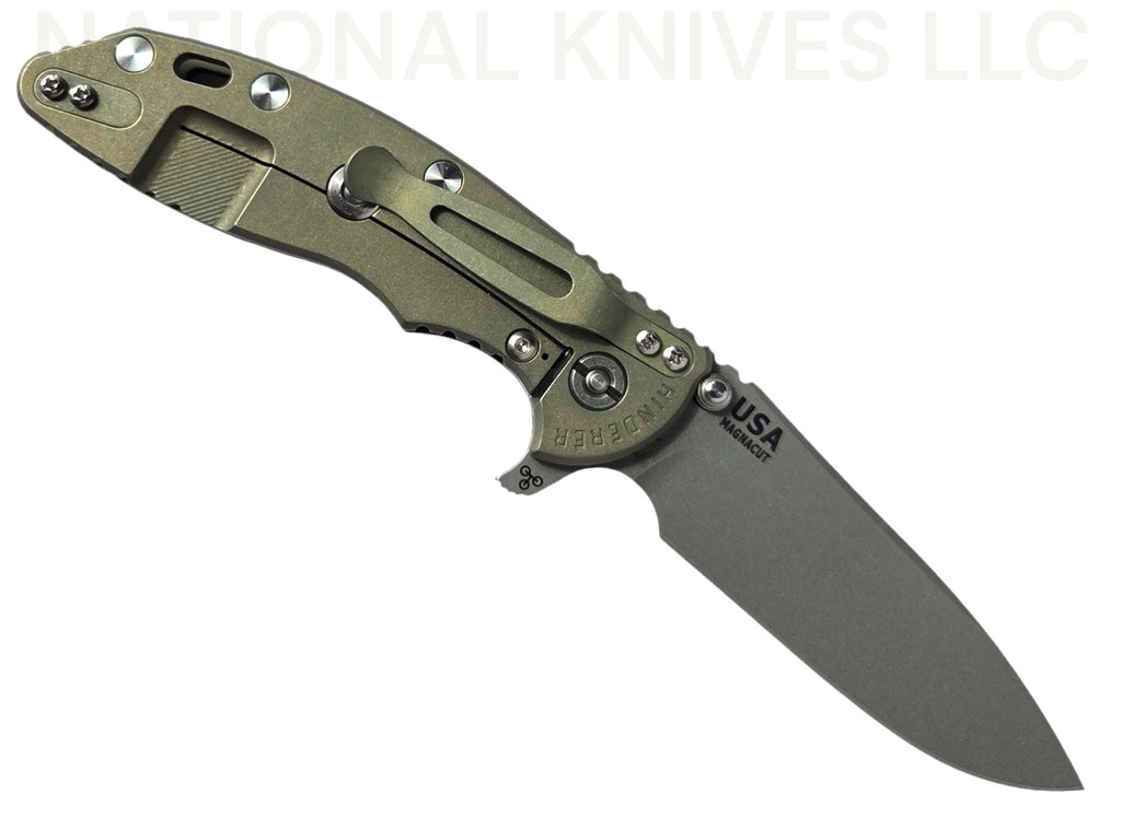 Rick Hinderer Knives XM-18 Skinny Slicer with thumb stud and flipper tab - shown open lock side.  Working Finish Magnacut stainless steel, hollow ground, plain edge blade.  Black G-10 handle with Battle Green lock side. 