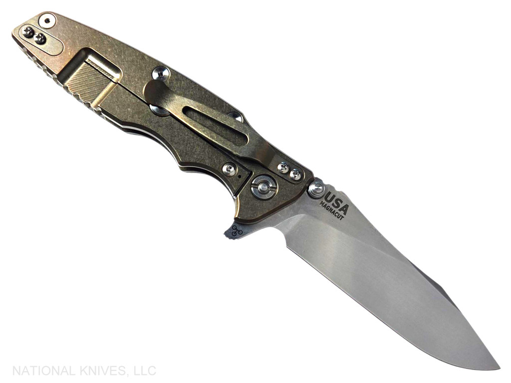 Rick Hinderer Knives Skinny Eklipse Slicer folding knife with flipper tab - shown open - lock side.  Stonewash 3.5" hollow grind MagnaCut stainless steel plain edge blade.  Translucent Green G-10 handle scale with stonewashed bronze lock side.  Model KEK35SKSLHO
