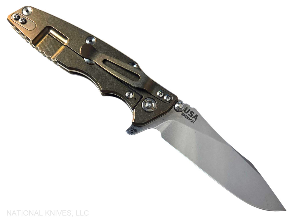 Rick Hinderer Knives Skinny Eklipse Slicer folding knife with flipper tab - shown open - lock side.  Stonewash 3.5" hollow grind MagnaCut stainless steel plain edge blade.  Blue - black G-10 handle scale with stonewashed bronze lock side.  Model KEK35SKSLHO