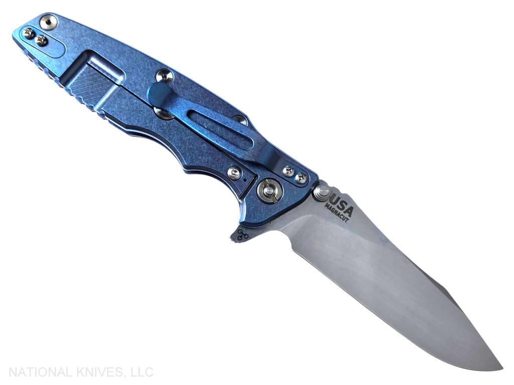 Rick Hinderer Knives Skinny Eklipse Slicer folding knife with flipper tab - shown open - lock side.  Stonewash 3.5" hollow grind MagnaCut stainless steel plain edge blade.  Red G-10 handle scale with stonewashed blue lock side.  Model KEK35SKSLHO