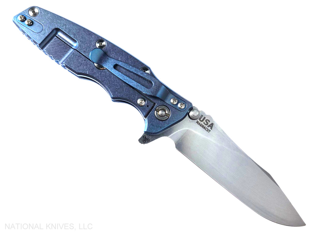 Rick Hinderer Knives Skinny Eklipse Slicer folding knife with flipper tab - shown open - lock side.  Stonewash 3.5" hollow grind MagnaCut stainless steel plain edge blade.  Blue G-10 handle scale with stonewashed blue lock side.  Model KEK35SKSLHO
