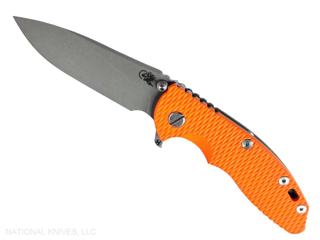Rick Hinderer Knives XM-18 3.5" Slicer Hollow Grind folding knife with thumb stud and flipper tab - shown open presentation side.  Working Finish 20CV stainless steel plain edge blade.  Orange G-10 handle with Battle Bronze lock side.  Model KXM35SLHO.