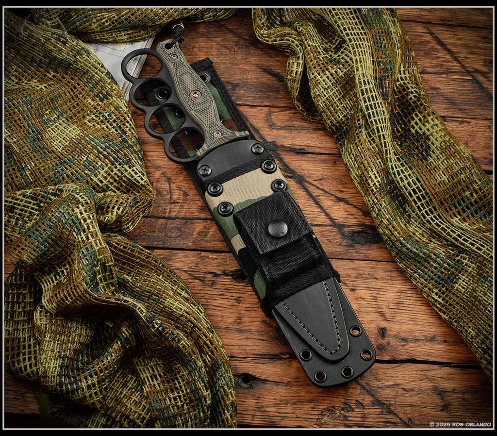 RMJ Tactical Trench Raider - shown in sheath obverse. Graphite Black Cerakote 3V steel double plain edge blade.  Dirty Olive G-10 handle scales.  Model K-TR-3V-GB-DO-BWD.