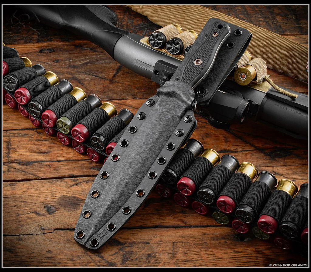 RMJ Tactical Kilroy fixed blade knife - shown in sheath obverse.  Acid Etched with black Cerakote Resist Camo M390 steel, double plain edge, blade.  Black G-10 handle scales. Model K-KRY-M390-CAE-BLK.